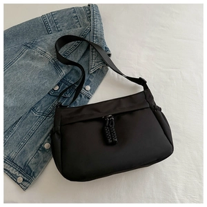 Détail du sac cabas en nylon noir avec tissu résistant et tirettes de fermeture tissées