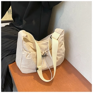 Close-up of beige nylon crossbody bag with drawstring detail and adjustable strap