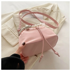 Detail of pink drawstring bucket bag with decorative pearl and silver metal bead handle