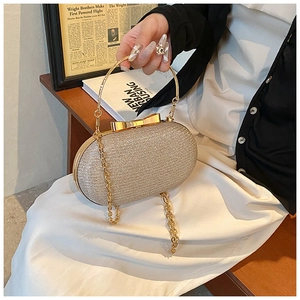 Detail of sequined evening clutch with gold bow clasp and metallic ring handle