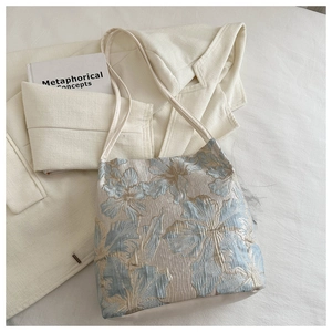 Détails du tissu jacquard floral et finitions en cuir blanc sur un sac style chinois