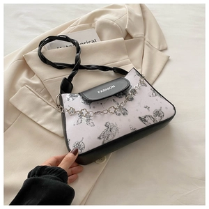 Detail of lavender butterfly print shoulder bag with black 'FASHION' flap and floral chain