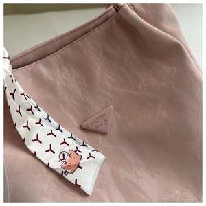 Detailansicht der rosa gerafften Tragetasche mit Dekoschal und Mode-Emblem