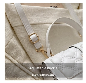 Detail of adjustable golden buckle and white quilted leather strap on shoulder bag