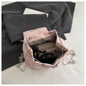 Interior view of pink velvet bucket bag showing space for glasses and a white wallet