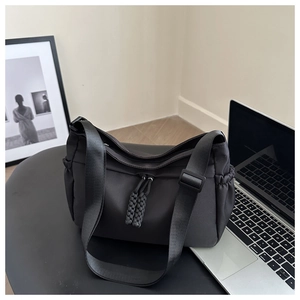 Close-up of black nylon tote bag with utility pockets on a desk for daily commute
