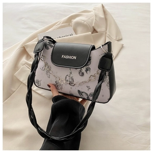 Detail of a chic black and white contrast shoulder bag with butterfly print and gold chain