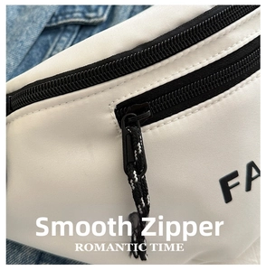 Detail of smooth black zipper with cord puller on a white textured sports waist bag