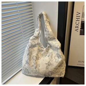 Detail shot of white canvas tote bag with butterfly prints and fuzzy texture finish