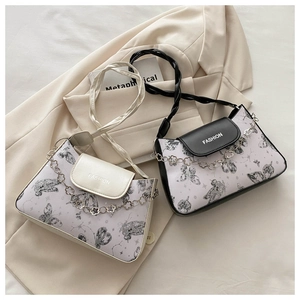Detail of trendy PU leather crossbody bags with butterfly prints and metal flower chain