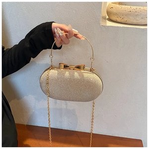 Detail of gold sequin evening bag with metal bow clasp and round handle link