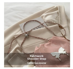 Détail du sac seau rose avec ornement papillon argenté et bandoulière en chaîne