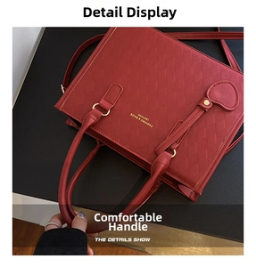 Detail view of red quilted leather handbag with gold lettering and sturdy handles