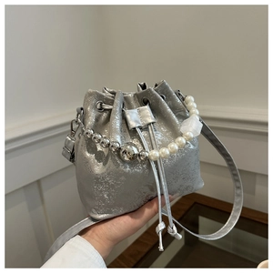 Detail of silver drawstring bucket bag with pearl chain handle and metallic texture