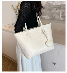 Detail of off-white tote bag with pleated leather texture and puffy heart charm