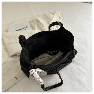 Detail der schwarzen Textur-Tote-Bag mit großem Fassungsvermögen, Seidentuch und Flechtgriff