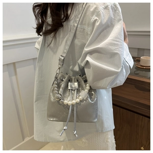 Chic silver metallic bucket bag with pearl handle and drawstring closure detail