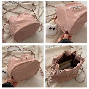 Vues détaillées du sac seau rose marbré avec bandoulière chaîne et porte-clé en peluche