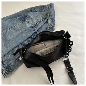 Detail of black canvas crossbody bag showing spacious interior with dual strap options