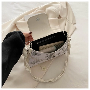 Internal view of a white PU crossbody bag with butterfly prints and magnetic closure