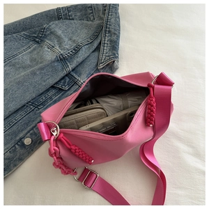 Interior view of large capacity pink nylon crossbody bag with wide strap and chain detail