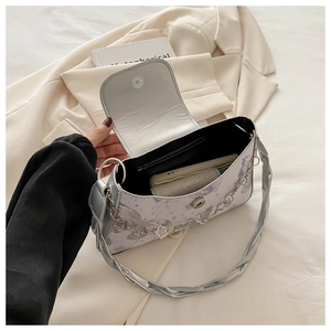Detail of butterfly print shoulder bag with silver twisted handle and clover chain decoration