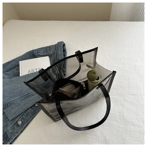 Vue détaillée d'un sac cabas en PVC transparent avec bordure en cuir noir et pochette