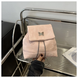 Detailed close-up of pink mini backpack with silver butterfly hardware and metal chain
