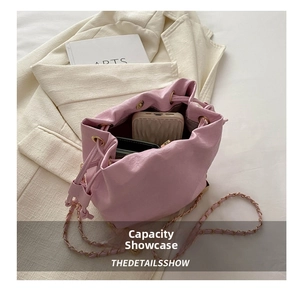 Pink leather bucket bag showing inner capacity for phone and cards with chain strap