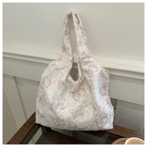 Detail of floral butterfly canvas tote bag with textured jacquard and fringe details