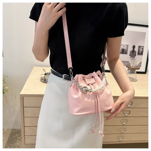 Detail of pink pearl strap bucket bag with glossy finish and drawstring closure