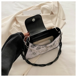 Detail of butterfly print handbag with metallic flower chain on a light blazer