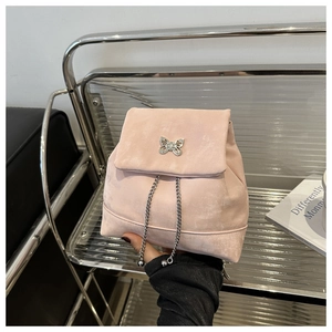 Detail of pink velvet mini backpack featuring silver butterfly hardware and chain drawstring