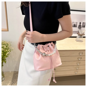 Pink glossy leather bucket bag featuring white pearl and silver bead handle details