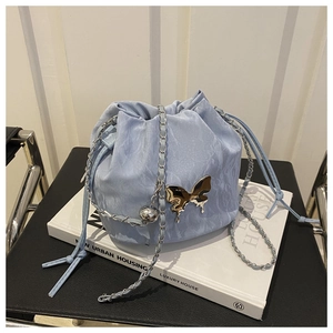 Macro detail of light blue drawstring bucket bag with silver liquid butterfly hardware