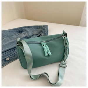 Detail of mint green nylon bag with matching plastic chain and woven zipper pull