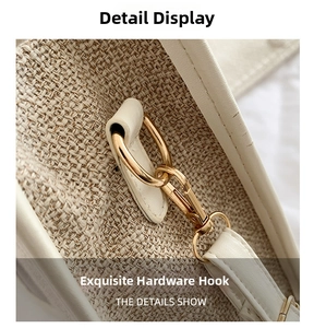 Close-up of golden hardware hook and fine stitching on white canvas tote bag