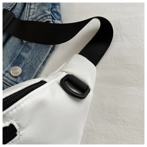 Macro detail of white nylon waist bag showing durable stitching and black D-ring buckle