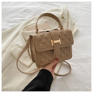 Detail of khaki quilted crossbody bag with golden metal lock and elegant top handle