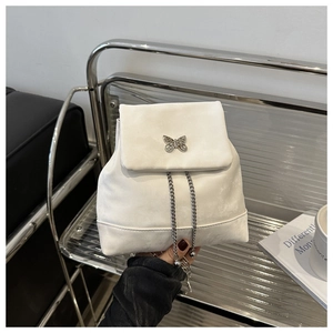 Detail of off-white suede mini backpack featuring a silver butterfly buckle and chain