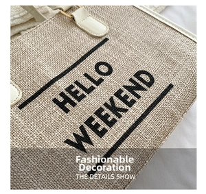 Close-up of the woven canvas tote bag featuring black HELLO WEEKEND print and white leather handle