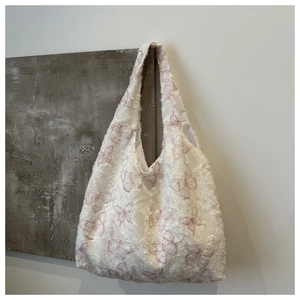 Close-up of lace butterfly print and frayed edges on white large canvas tote bag