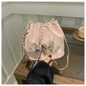 Detailed close-up of pink marble texture bucket bag with gold butterfly metal hardware