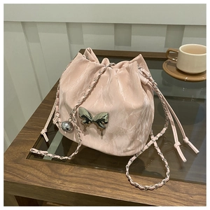 Detail of pink bucket bag with metallic butterfly buckle and silver chain strap