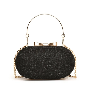 Sparkly black oval evening clutch bag with gold ring handle and bow clasp detail