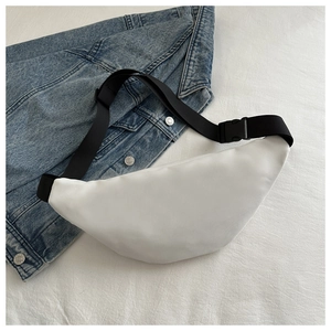Detail of white nylon waist bag with adjustable black strap on denim fabric background
