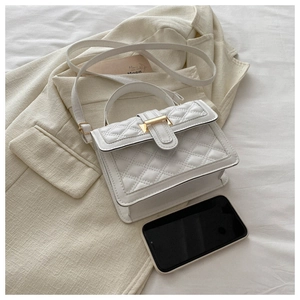 Quilted beige crossbody bag with gold buckle and phone for size comparison