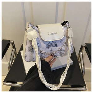 Detail of lavender bag with butterfly pattern and silver fashion logo on white flap