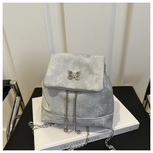 Detail of silver velvet mini backpack showing butterfly clasp and chain drawstring