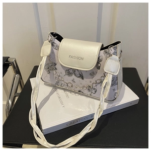 Detail of white leather shoulder bag featuring grey butterfly print and silver flower chain